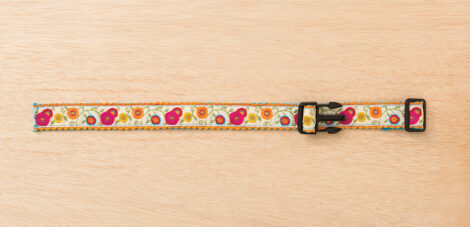 fabric being threaded through the pronged side of a parachute buckle